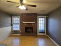 Bright living room with hardwood floors, a brick fireplace, and natural light from two windows at 634 S Jeff Davis Dr, Fayetteville, GA 30215