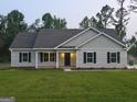 Attractive single-story home with black shutters and manicured front lawn with an inviting entryway at 22638 Salem Church Rd, Metter, GA 30349