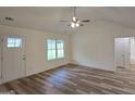 Bright, vaulted living room featuring new vinyl flooring and an exit door to the outdoors at 22638 Salem Church Rd, Metter, GA 30349
