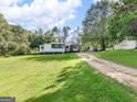 Inviting single-story home featuring a well-manicured lawn and a covered carport at 1202 Coan Dr, Locust Grove, GA 30248