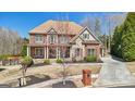 Gorgeous two-story brick home with stone accents, a well-maintained lawn, and mature landscaping at 3149 Hidden Falls Ne Dr, Buford, GA 30519
