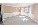 Elegant dining room with wainscoting, a chandelier, and a large bay window at 159 Courtneys Ln, Fayetteville, GA 30215