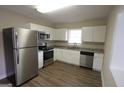 Modern kitchen with stainless steel appliances, granite countertops, white cabinets, and wood-look flooring at 1923 Rosewood Rd, Decatur, GA 30032