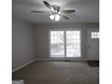 Bright living room featuring neutral paint, plush carpeting, and natural light from large window at 2509 Appomattox Dr, Decatur, GA 30034