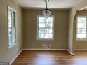 Dining area showcasing hardwood floors, a decorative chandelier, and abundant natural light from large windows at 1271 Sanders Dr, Lake City, GA 30260
