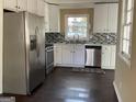 Well-lit kitchen featuring stainless steel appliances, modern backsplash, and ample counter space at 1271 Sanders Dr, Lake City, GA 30260