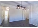 Bright dining room featuring modern light fixture, wainscotting and elegant gray flooring at 8030 Snapwell Dr, Fairburn, GA 30213