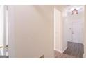 Bright hallway featuring gray flooring, white trim, and views into adjacent rooms at 8030 Snapwell Dr, Fairburn, GA 30213