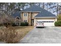 Traditional-style home with a dark roof, stone accents, and an attached garage, captured on a sunny day at 1593 Brynwood Nw Ct, Acworth, GA 30101