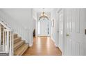 Inviting foyer with hardwood floors, white trim, a chandelier, and a staircase leading to the upper level at 1593 Brynwood Nw Ct, Acworth, GA 30101