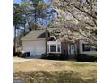 Charming two-story home with brick facade and blossoming tree in the front yard at 645 Legend Sw Ct, Atlanta, GA 30331