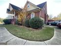 Brick home with a well-manicured lawn, attached garage, and mature shrubs at 239 Overland Trl, Mcdonough, GA 30252
