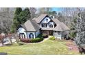 Aerial view of a stunning two-story home with a well-manicured lawn and mature trees at 4852 Jacobs Cove Pt, Buford, GA 30519