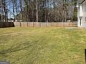 Large, fenced-in backyard with a well-maintained lawn, providing ample space for outdoor activities at 1126 Old Jackson Rd, Locust Grove, GA 30248