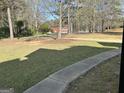 Well-maintained front yard featuring green grass, mature trees, and a paved walkway at 1126 Old Jackson Rd, Locust Grove, GA 30248