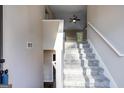 Bright foyer with carpeted stairs, neutral paint, and modern lighting leading to the home's upper level at 217 Old Carrollton Rd, Carrollton, GA 30116