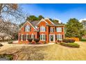 Charming two-story red brick home with a beautifully landscaped front yard at 265 Ridgewood Dr, Fayetteville, GA 30215