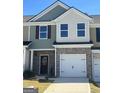 Attractive two-story townhome boasting a brick base, green siding, and a convenient attached garage at 8642 Lakeview Commons # 36, Jonesboro, GA 30238