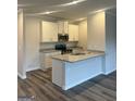 Modern kitchen featuring white cabinetry, granite countertops, stainless steel appliances, and hard floors at 8642 Lakeview Commons # 36, Jonesboro, GA 30238