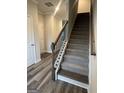 Entryway staircase featuring hardwood floors, neutral paint, modern railing, and natural light at 8642 Lakeview Commons # 36, Jonesboro, GA 30238