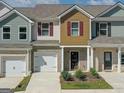 Well-maintained townhome featuring a brick base, garage, neutral siding, and complementing landscaping at 8660 Lakeview Commons # 39, Jonesboro, GA 30238