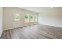 Bright living room with wood-look flooring, ample natural light, and a neutral color palette at 8660 Lakeview Commons # 39, Jonesboro, GA 30238