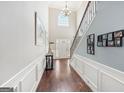 Bright foyer with hardwood floors, chandelier, and staircase with iron balusters at 605 Camano Way, Mcdonough, GA 30253