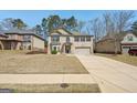 Charming two-story brick home with a manicured lawn, and attached two car garage at 605 Camano Way, Mcdonough, GA 30253