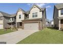 Charming two-story home showcasing a brick and siding exterior with an attached two-car garage at 2458 Walker Dr, Hampton, GA 30228