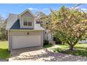 Exterior of home with flowering tree showing a garage, front door, and maintained lawn at 4542 White Rd, Douglasville, GA 30135