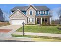 Charming two-story home featuring brick accents, white trim, a well-kept lawn, and a two car garage at 8110 Brewton Bnd, Cumming, GA 30028