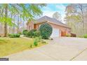 Brick home with attached garage, concrete driveway, and manicured landscaping at 165 Hideaway Dr, Fayetteville, GA 30215