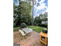 Spacious backyard featuring a brick patio with outdoor dining set and a built-in grill perfect for entertaining at 497 Pine Haven Ln, Atlanta, GA 30342