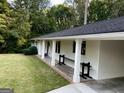 Inviting home exterior featuring a brick accent, covered parking area, and well-maintained landscaping at 497 Pine Haven Ln, Atlanta, GA 30342