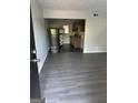 View from doorway into living room with wood-look floors and a glimpse into the kitchen with black appliances at 6540 Lower Dixie Lake Rd, Union City, GA 30291