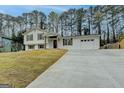 Spacious split-level home with a long concrete driveway leading to an attached two-car garage at 5155 Rosestone Nw Dr, Lilburn, GA 30047
