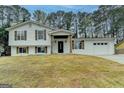 Charming split-level home featuring a fresh white exterior, rustic shutters, and attached two-car garage at 5155 Rosestone Nw Dr, Lilburn, GA 30047
