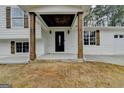 Inviting front porch with wood columns and a black front door enhance the home's curb appeal at 5155 Rosestone Nw Dr, Lilburn, GA 30047
