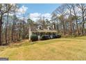 Scenic view of a charming home surrounded by lush greenery and mature trees at 375 Wellington Mill Rd, Whitesburg, GA 30185