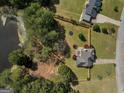 Aerial view of a fenced property with a deck, mature trees, and proximity to a serene pond at 720 Strawflower Ln, Locust Grove, GA 30248