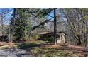 Exterior view of a cozy single-story home surrounded by mature trees and natural landscape at 768 Scales Rd, Suwanee, GA 30024