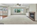 Bright living room with coffered ceiling, fireplace, built-ins, and large windows overlooking the backyard at 3393 Willow Glen Trl, Suwanee, GA 30024
