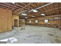 Expansive garage interior with built-in shelving, workbench, and natural light from multiple windows at 3530 Highway 81 W, Hampton, GA 30228