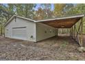 Spacious garage with a car port and a roll up door on a tree covered lot at 3530 Highway 81 W, Hampton, GA 30228