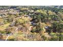 Expansive aerial view of a home nestled among lush trees in a peaceful neighborhood, near a small lake at 135 Horseshoe Cir, Fayetteville, GA 30215