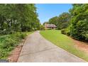 Scenic view of a home from a long driveway showcasing a beautiful lawn at 135 Horseshoe Cir, Fayetteville, GA 30215