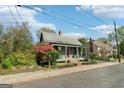 Charming home with a metal roof, inviting front porch, and vibrant landscaping, set on a tree-lined street at 1009 Institute Nw St, Conyers, GA 30012
