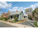 View of the charming cottage-style home with metal roof and inviting porch, showcasing its curb appeal at 1009 Institute Nw St, Conyers, GA 30012