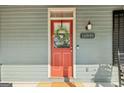Close-up of a welcoming red front door with glass panel, adorned with a wreath and house number at 1009 Institute Nw St, Conyers, GA 30012