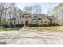 Stately home featuring a lush lawn, mature trees, and a circular driveway with a decorative fountain centerpiece at 115 Flagstop Run, Fayetteville, GA 30215